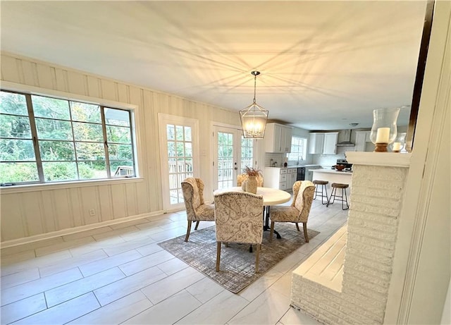 dining space with french doors and a notable chandelier