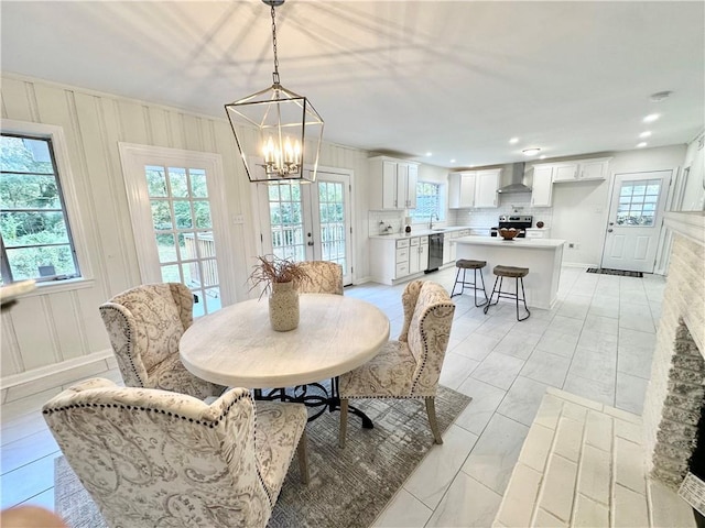 tiled dining room featuring plenty of natural light, a chandelier, french doors, and sink