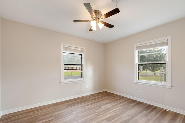 empty room with baseboards, light wood finished floors, and a healthy amount of sunlight