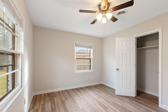 unfurnished bedroom featuring light wood-style floors, baseboards, visible vents, and a closet