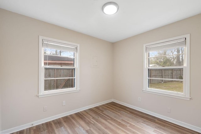 spare room with light wood-type flooring and baseboards