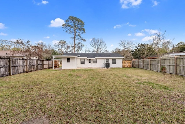 rear view of property featuring a yard and a fenced backyard