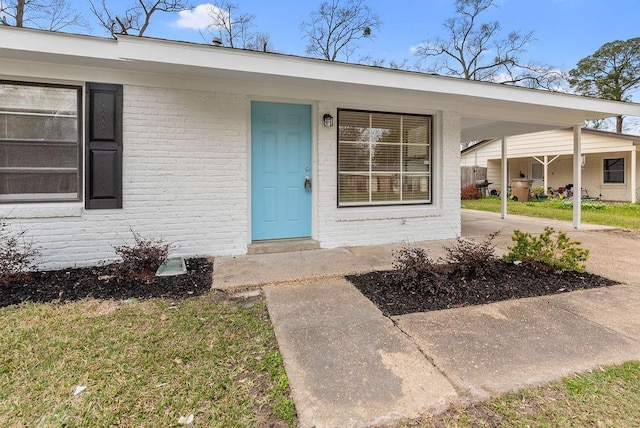 view of exterior entry with brick siding