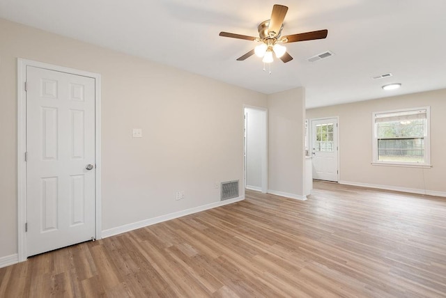 unfurnished room with visible vents, light wood-style flooring, and baseboards