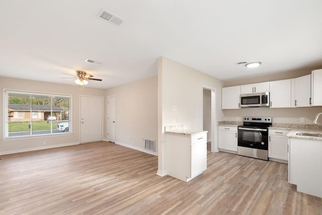 kitchen with light wood-type flooring, visible vents, appliances with stainless steel finishes, and a sink