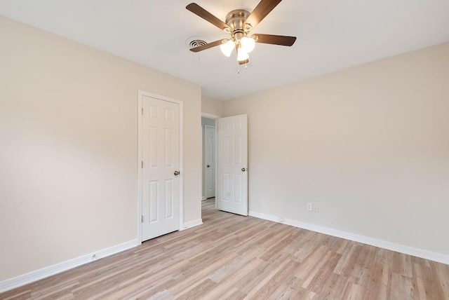 empty room with visible vents, baseboards, light wood-style flooring, and a ceiling fan