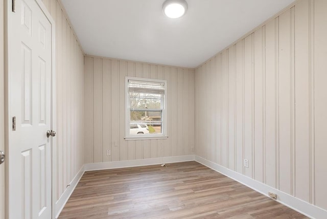 spare room with light wood-style floors and baseboards