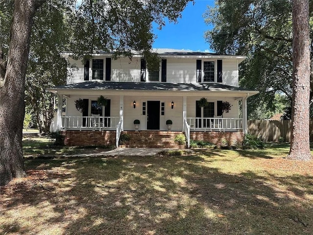 view of front of house with covered porch, fence, and a front yard