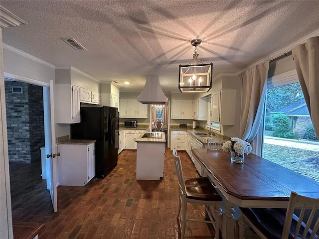 kitchen featuring a sink, a chandelier, crown molding, black appliances, and a kitchen island