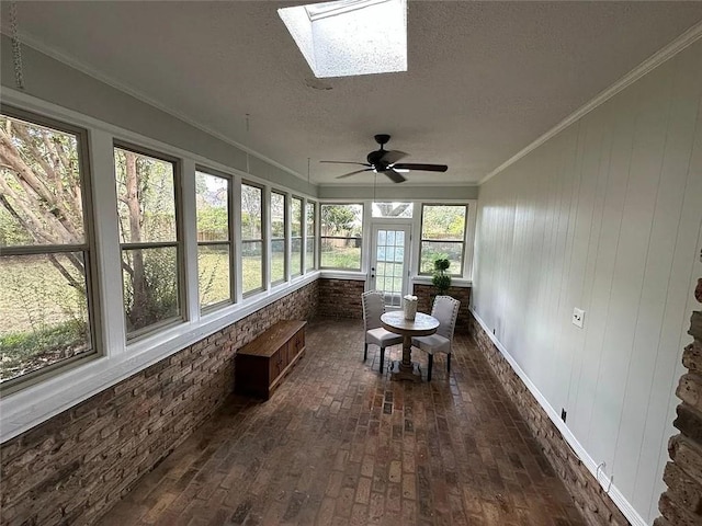 sunroom / solarium featuring a ceiling fan and a skylight
