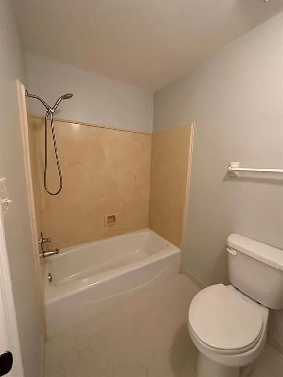 bathroom with toilet, tile patterned flooring, baseboards, and  shower combination