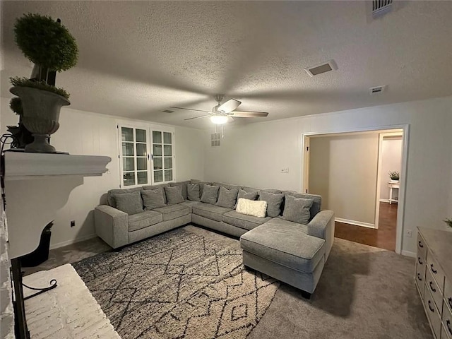 carpeted living area with ceiling fan, a textured ceiling, and visible vents