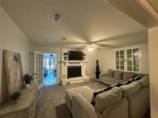 living area with visible vents, dark colored carpet, ceiling fan, and a textured ceiling