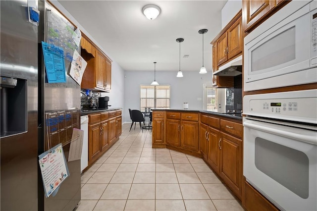 kitchen with kitchen peninsula, tasteful backsplash, white appliances, hanging light fixtures, and light tile patterned flooring