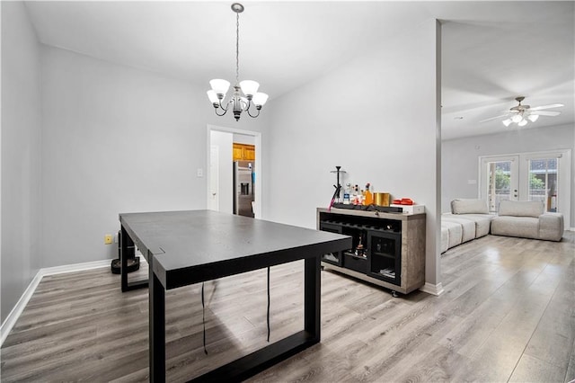 dining space featuring french doors, light hardwood / wood-style floors, and ceiling fan with notable chandelier