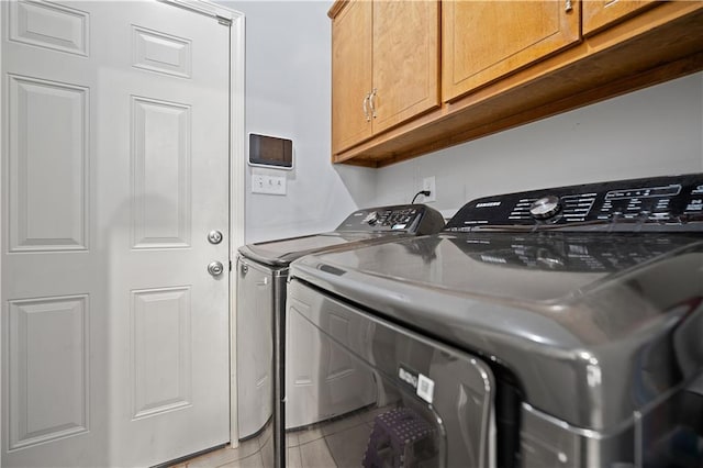 washroom with cabinets, light tile patterned flooring, and washing machine and dryer