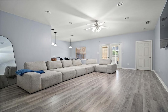 living room with ceiling fan and light wood-type flooring