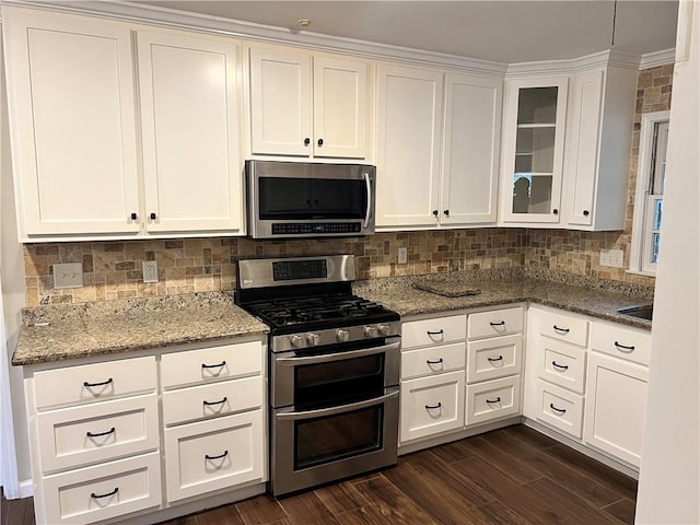 5855 Zeigler Blvd, Mobile, AL 36608 - kitchen featuring stainless steel appliances, white cabinetry, decorative backsplash, light stone counters, and dark wood-type flooring