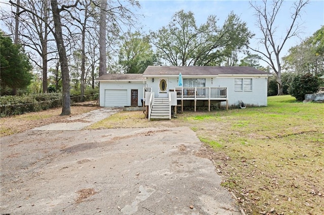 view of front of house with a garage, a wooden deck, and a front lawn