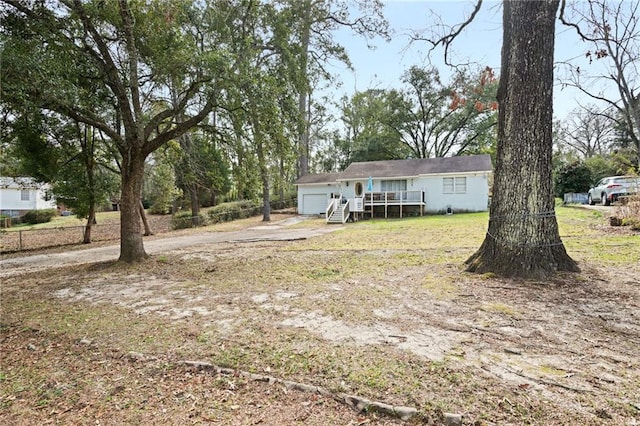 view of yard featuring a garage and a wooden deck