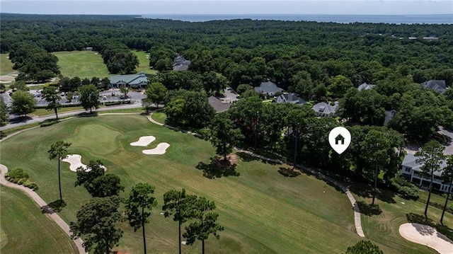 drone / aerial view featuring view of golf course and a forest view