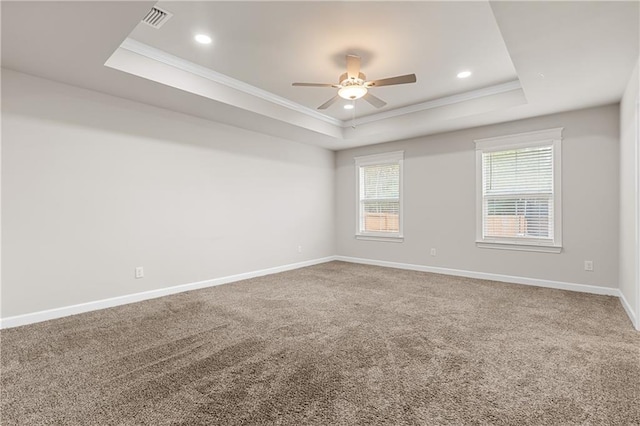 unfurnished room with ceiling fan, ornamental molding, carpet flooring, and a raised ceiling