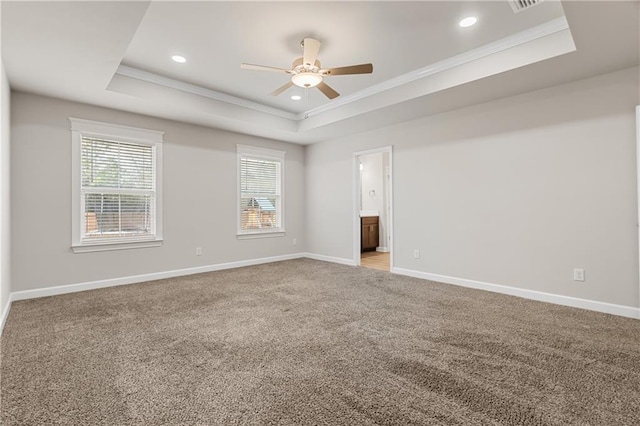 unfurnished room with a raised ceiling, crown molding, light carpet, and ceiling fan