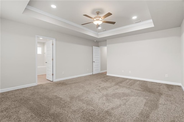 carpeted spare room featuring crown molding, ceiling fan, and a tray ceiling