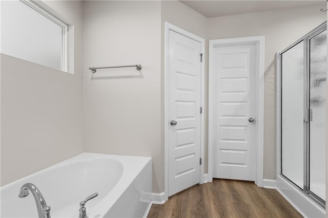 bathroom featuring wood-type flooring and separate shower and tub