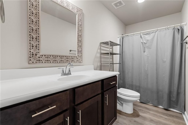 bathroom with vanity, hardwood / wood-style floors, a shower with curtain, and toilet