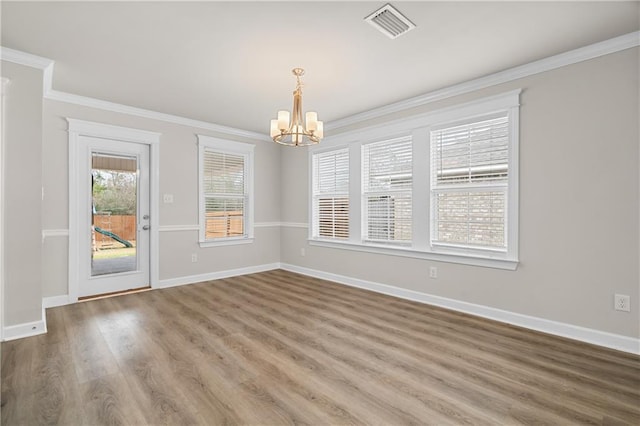 unfurnished dining area featuring crown molding, a notable chandelier, and hardwood / wood-style flooring