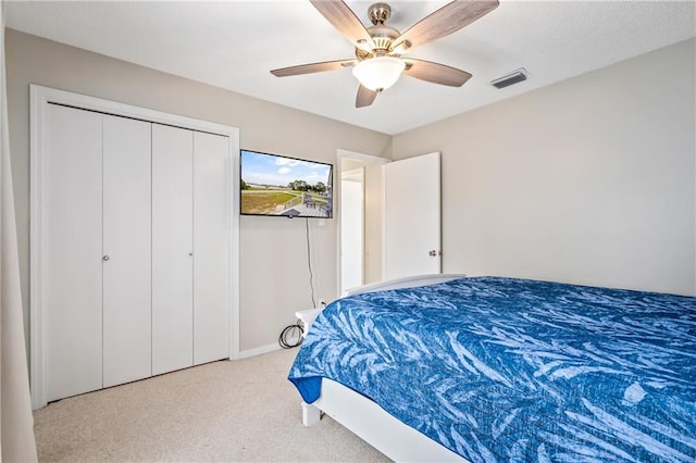 carpeted bedroom with ceiling fan, a closet, and baseboards