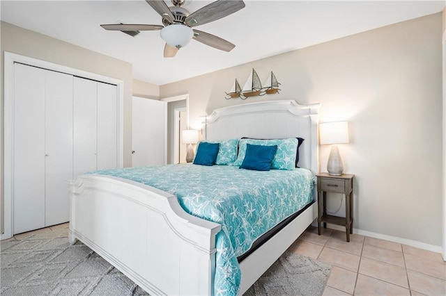 bedroom featuring a closet, ceiling fan, baseboards, and light tile patterned flooring