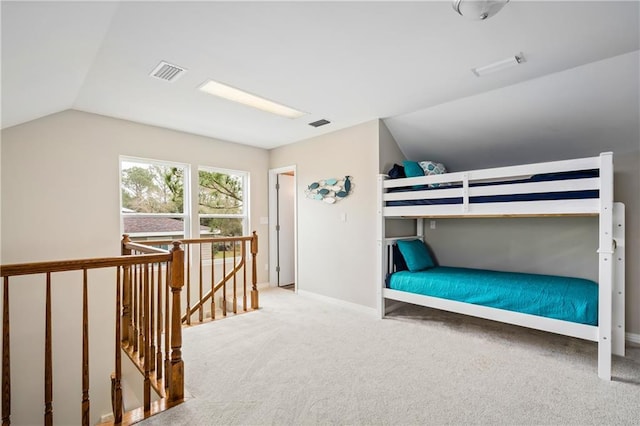 carpeted bedroom with lofted ceiling and baseboards