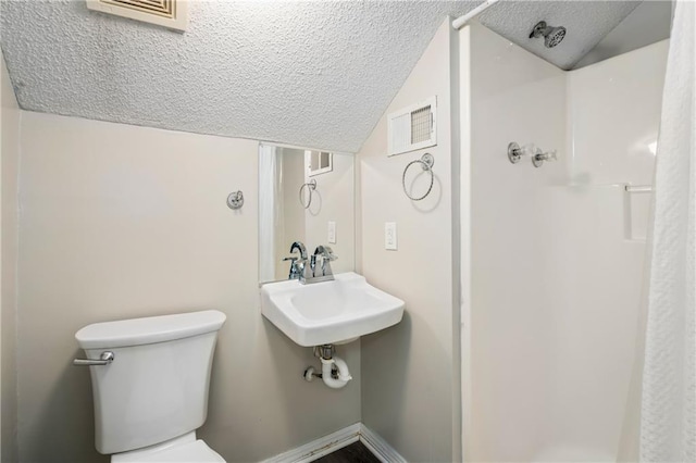 full bathroom featuring a textured ceiling, lofted ceiling, a shower, and toilet