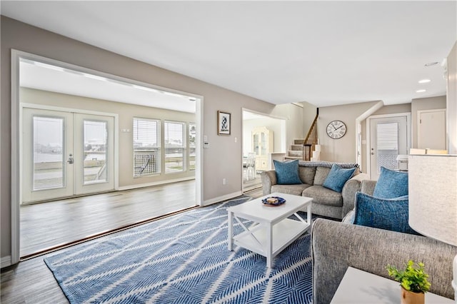 living area with stairs, wood finished floors, baseboards, recessed lighting, and french doors