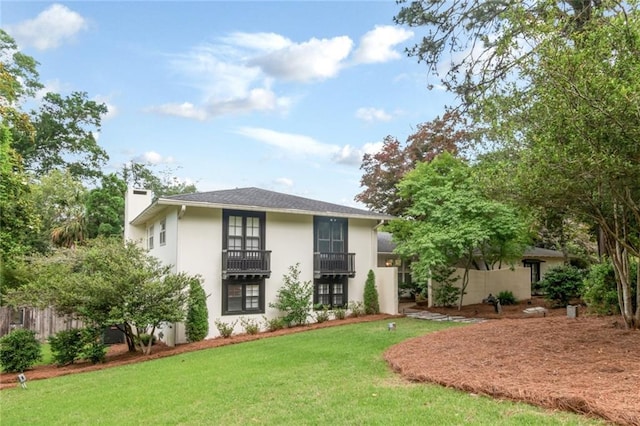 6000 Shenandoah Rd N, Mobile, AL 36608 - rear view of property featuring a lawn, stucco siding, a balcony, and a chimney