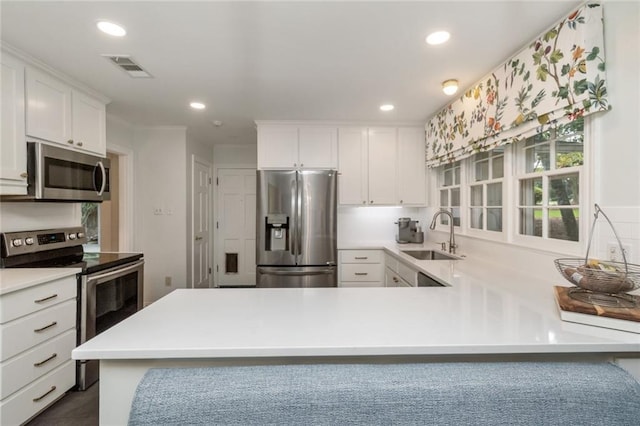 6000 Shenandoah Rd N, Mobile, AL 36608 - kitchen with appliances with stainless steel finishes, a sink, recessed lighting, light countertops, and white cabinetry