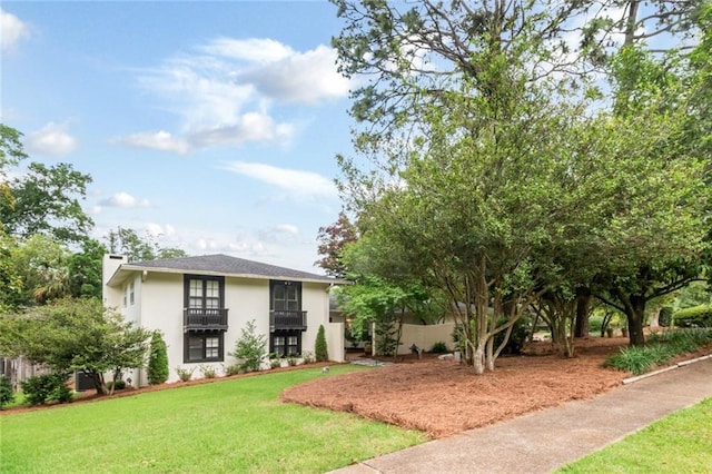6000 Shenandoah Rd N, Mobile, AL 36608 - view of front of property with a front yard, stucco siding, a chimney, and a balcony