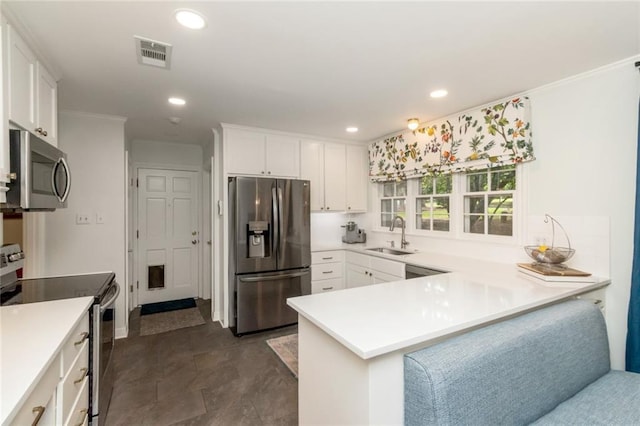 6000 Shenandoah Rd N, Mobile, AL 36608 - kitchen featuring appliances with stainless steel finishes, a sink, a peninsula, white cabinetry, and recessed lighting