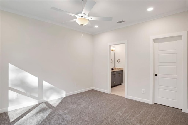 unfurnished bedroom with ensuite bathroom, ceiling fan, and light carpet