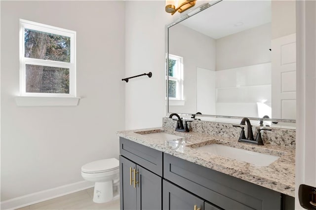 bathroom with vanity, toilet, and plenty of natural light