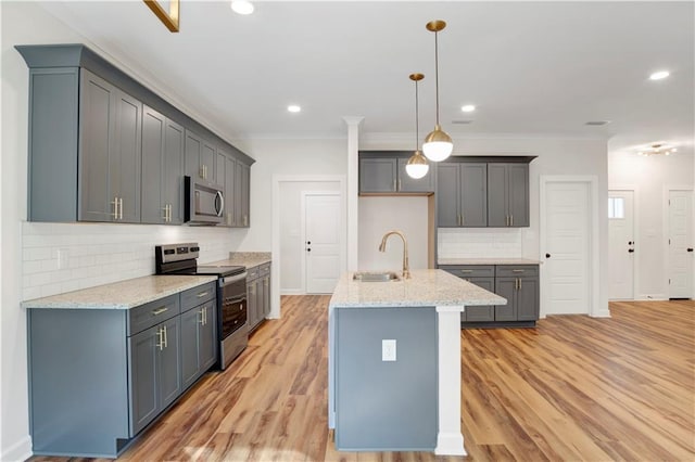 kitchen featuring sink, light stone counters, light hardwood / wood-style flooring, backsplash, and appliances with stainless steel finishes