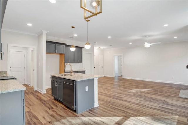 kitchen featuring light wood-type flooring, sink, dishwasher, hanging light fixtures, and an island with sink