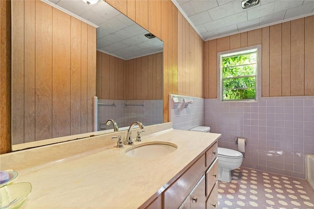 66 Mccoy Ave, Satsuma, AL 36572 - full bathroom featuring vanity, toilet, wooden walls, tile patterned floors, and a wainscoted wall