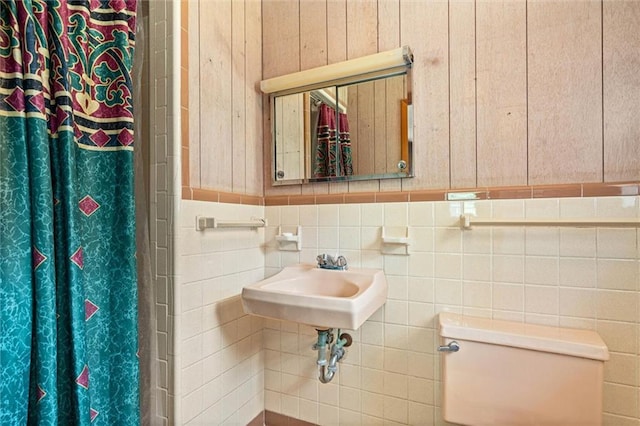 66 Mccoy Ave, Satsuma, AL 36572 - bathroom featuring toilet, curtained shower, tile walls, and a sink