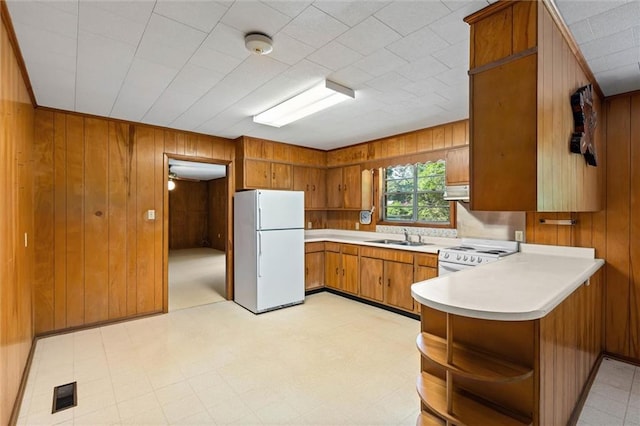 66 Mccoy Ave, Satsuma, AL 36572 - kitchen with white appliances, open shelves, brown cabinetry, a peninsula, and a sink
