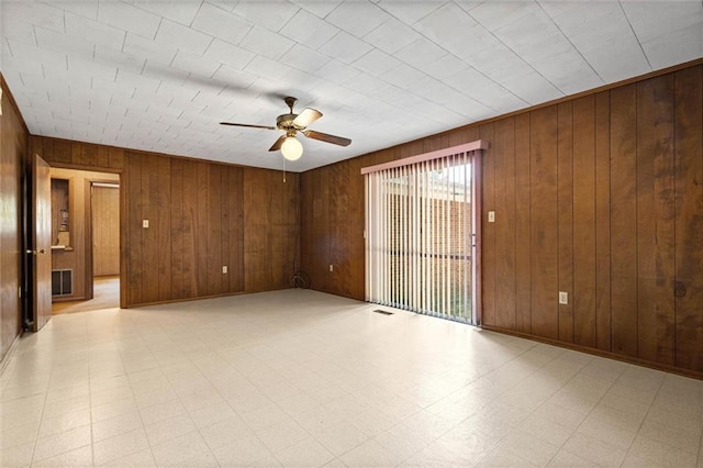 66 Mccoy Ave, Satsuma, AL 36572 - spare room with a ceiling fan, wood walls, and light floors