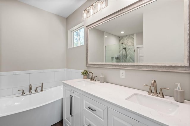 bathroom with a soaking tub, a sink, a shower stall, and double vanity