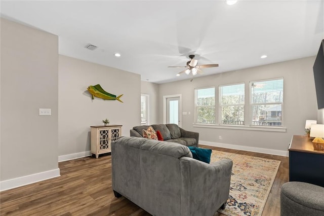 living room with dark wood-style floors, recessed lighting, visible vents, and baseboards